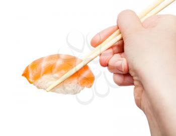 female hand with disposable chopsticks holds sake nigiri sushi with salmon close up isolated on white background