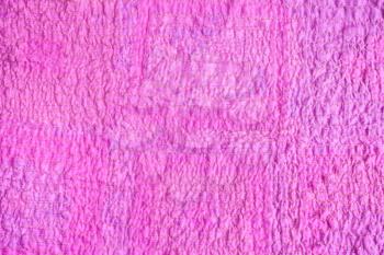 textile background - surface of scarf stitched from crushed pink cotton fabric