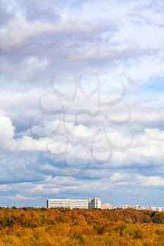 white and gray clouds in blue sky over yellow city park on sunny autumn day