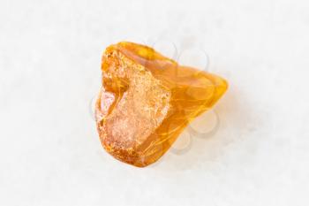 closeup of sample of natural mineral from geological collection - piece of Amber gemstone on white marble background from Baltic Sea, Kaliningrad, Russia