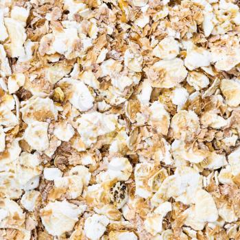 square food background - oat flakes with rye bran close up