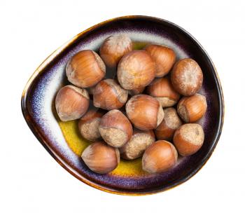 top view of whole hazelnuts in ceramic bowl isolated on white background