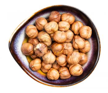 top view of shelled hazelnuts in ceramic bowl isolated on white background