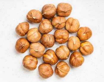 top view of pile of shelled hazelnuts close up on gray ceramic plate