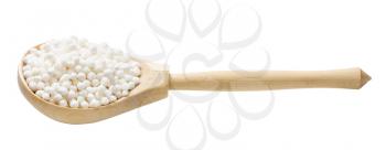 dry sabudana (tapioca sago) in wooden spoon isolated on white background