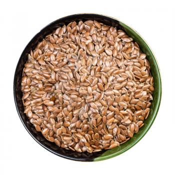 top view of brown flax seeds in round bowl isolated on white background