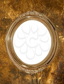 Golden oval photo frame with white isolated empty space inside on grungy wall.