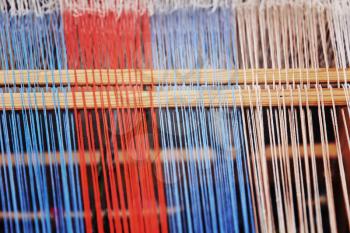 Multicolored thread on a weaving loom taken closeup.Toned image.