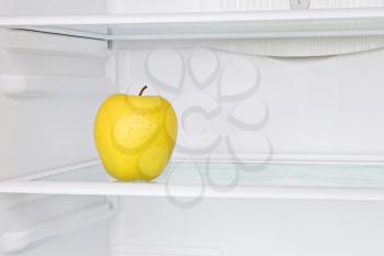 Lifestile concept.Yellow apple in domestic refrigerator taken closeup.