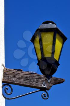 a  street lamp and a white wall  of house in calle de los suspiros in colonia del sacramento  uruguay