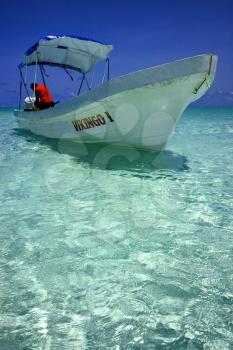 a boat in the blue lagoon of sian kaan in mexico