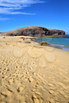 footstep coast people stone volcanic spain  water in lanzarote  sky cloud beach  and summer 
