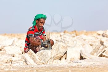 ETHIOPIA,DANAKIL-CIRCA  DECEMBER 2017--unidentified man working the block of salt