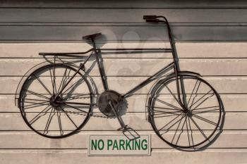  a no parkin signal in the garage door    and antique bicycle hanging 