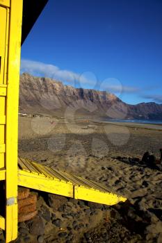 lifeguard chair cabin red flag in spain  lanzarote  rock stone sky cloud beach  water  musk pond  coastline and summer 
