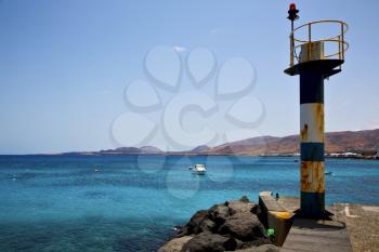 lighthouse and pier boat in the blue sky   arrecife teguise lanzarote spain
