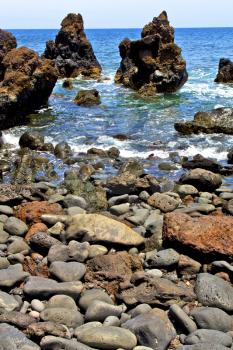 brown rock in white coast lanzarote   spain   beach  stone water  and summer hervideros