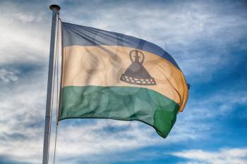 blur  in lesotho waving national flag in the cloudy sky