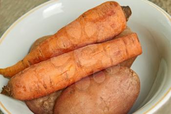 Boiled vegetables: potatoes and carrots on a plate close-up