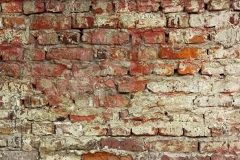 Fragment of old brick wall with shelled color paint layers