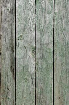 Several parallel old wooden boards with very ragged green paint