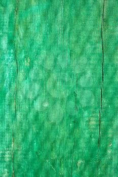 Shadow of grid on the old ragged wooden plank painted in green 