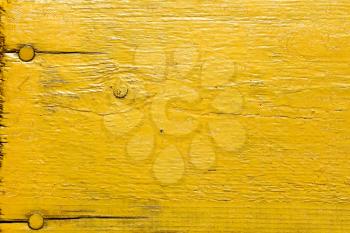 Painted yellow wooden desk with nails as a texture