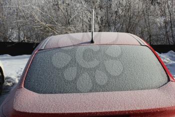 Frozen and snow-covered red car glass 30378
