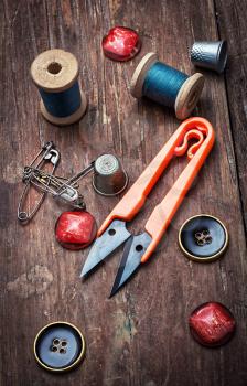 tools seamstresses on wooden background.the image is tinted in vintage style