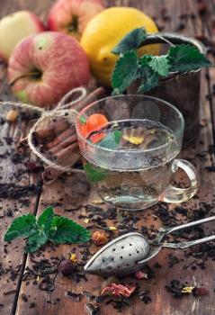 Apple tea with cinnamon on a background of custard spoons in the autumn style