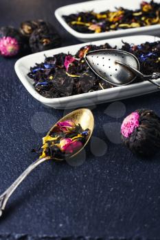 Spoon and saucer with a tea leaf on a slate blue background