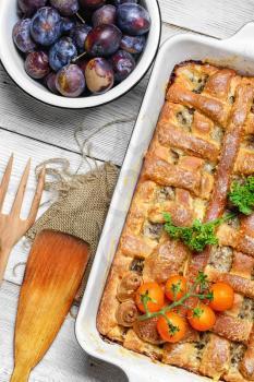 Baked according to traditional recipe meat pie with plums