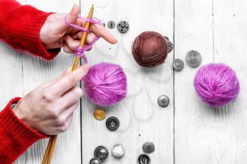 Female hands with knitting needles and balls of wool