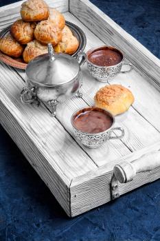 Homemade profiteroles dessert and cup hot chocolate