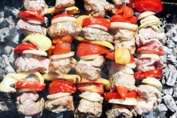 Cooking barbecue. Meat and vegetables tomato, bow, pepper, grilled on charcoal, close-up