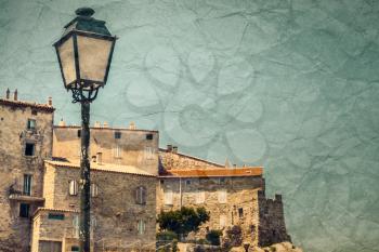 Street lamp in Sartene, Corsica, France. Vintage toned photo with old grungy paper texture