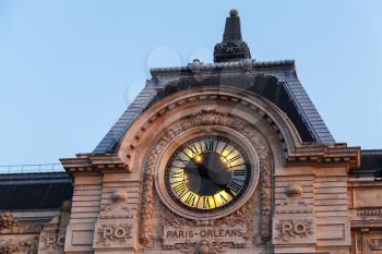 Evening illumination of famous ancient clock on the wall of Orsay Museum in Paris