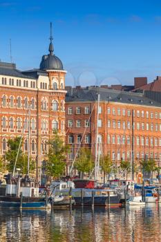 Old quay of Helsinki city with moored ships and classical building facades in the morning light