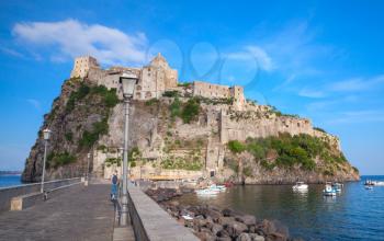 Coastal landscape of Ischia port with Aragonese Castle and road on the dam