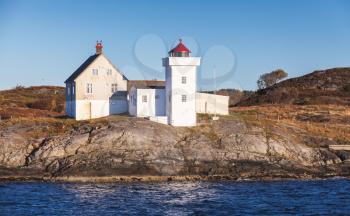 Terningen Lighthouse. White tower with red top. Coastal lighthouse located in Hitra Municipality, Trondelag county, Norway