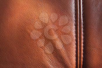Genuine leather with seam, brown background texture, close up