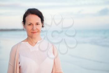 Young Caucasian woman, outdoor portrait on ocean coast in early morning