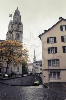 Cityscape of old Zurich in dark rainy day with Grossmunster church, Switzerland. Vintage toned photo