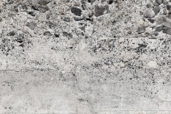 Rough concrete empty wall with stones, background photo texture