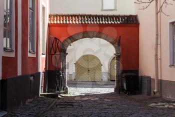 Old town of Tallinn, street fragment with red arch and wooden gate
