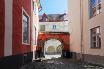 Old town of Tallinn, street fragment with red arch and wooden gates