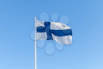 Flag of Finland, also called Blue Cross Flag waving over blue sky background