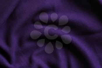 Texture of deep purple fleece, soft napped insulating fabric made from polyester, wavy pattern