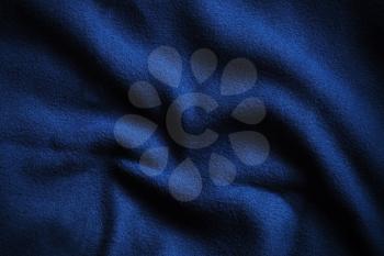 Texture of deep blue fleece, soft napped insulating fabric made from polyester, wavy pattern