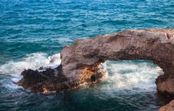 Stone arch known as the Love bridge. Natural landmark of Mediterranean Sea coast. Summer landscape of Ayia Napa, Cyprus island